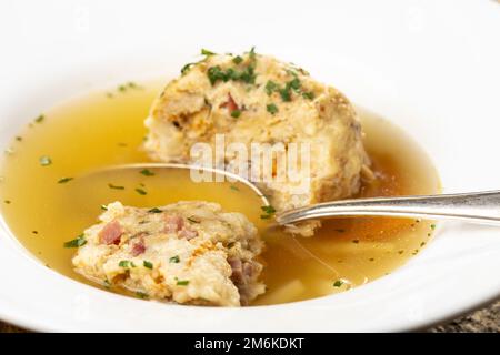 Zuppa con gnocchi di pancetta su legno Foto Stock