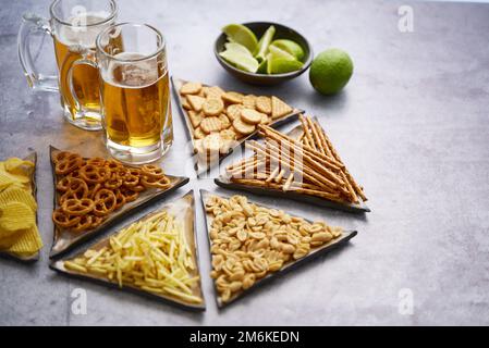 Vassoio con birra e spuntini al tavolo Foto Stock