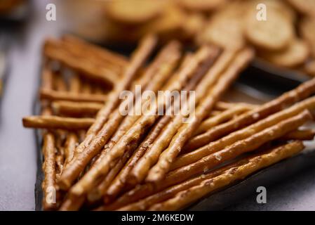 Primo piano di bastoncini salati su un piatto con cracker Foto Stock