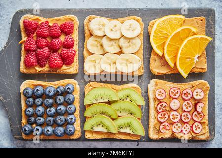 Cereali integrali fette di pane con burro di arachidi e frutti vari Foto Stock