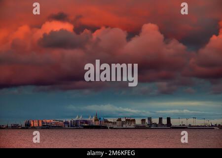 Cielo rosa magico sopra il complesso residenziale in costruzione sul lungofiume del fiume Neva sull'isola di Vasilievsky in sole Foto Stock