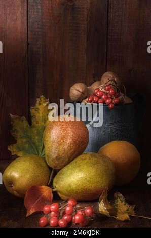 Pere mature su sfondo di legno scuro in stile rustico Foto Stock