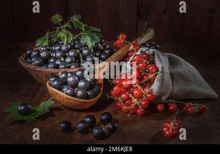 Bacche di ribes mature su fondo di legno scuro Foto Stock