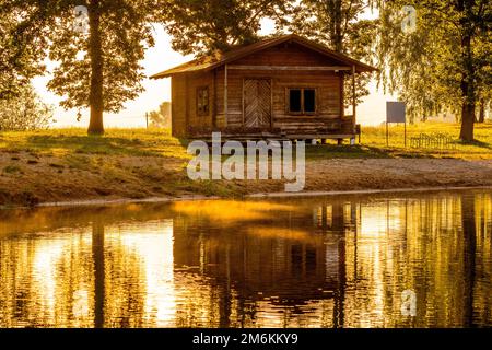 Casa estiva ecologica in legno vicino al lago la mattina presto soleggiato Foto Stock