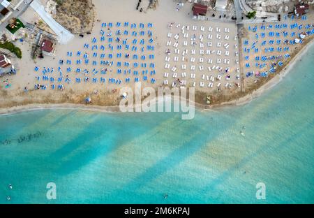 Ombrelloni in fila presso la spiaggia di fichi baie Protaras Cipro. Vacanze estive resort di vacanza. Foto Stock