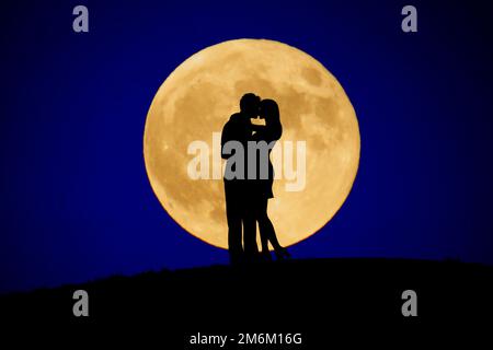 Due persone a baciare la luna nella schiena Foto Stock