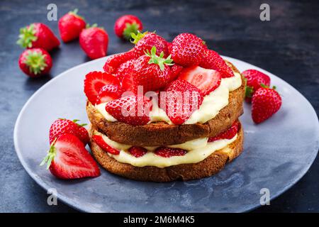 Tiramisù panettone tradizionale italiano arrosto con crema alla vaniglia e fragole servite come primo piano in un piatto di design Foto Stock