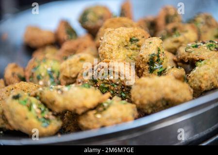 Un dettaglio ravvicinato di Falafel fritto appena cucinato, uno spuntino pieno di ceci e erbe popolare in Egitto e in tutto il Medio Oriente Foto Stock