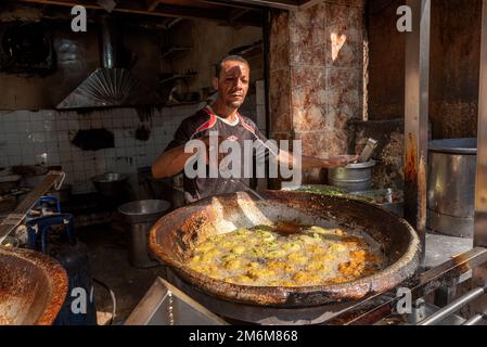 Cairo, Egitto. Novembre 26th 2022 un uomo egiziano friggere Falafel, uno spuntino ripieno di ceci e erbe popolare in Egitto e in tutto il Medio Oriente A. Foto Stock