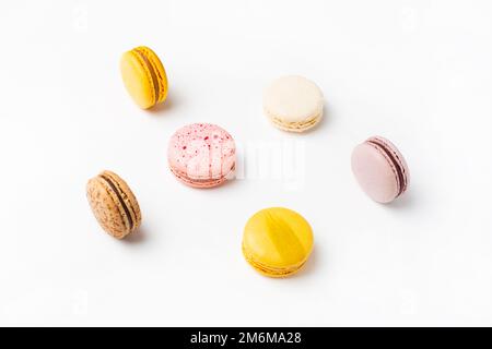 Macaroon cibo dolce su sfondo bianco. Sfondo giallo pastello, rosa. Foto Stock