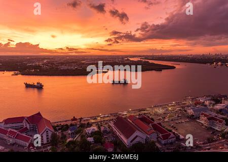 Vista dall'alto di Samut Prakan, Thailandia. Tramonto sul fiume Chao Phraya, cielo arancione. Foto Stock