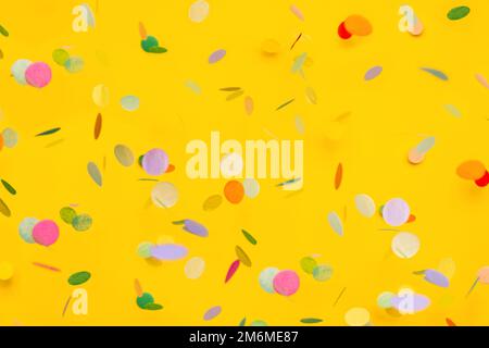 Coriandoli colorati su sfondo giallo. CopySpace per il testo. Sfondo festivo e luminoso. Foto Stock