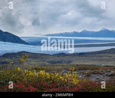 Splendida vista autunnale dal canyon di Mulagljufur al ghiacciaio di Fjallsarlon con la laguna ghiacciata di Breidarlon, Islanda. Non lontano dalla circonvallazione Foto Stock