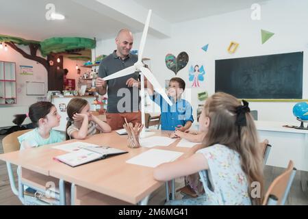 Scuola elementare Robotica STEM Classe diversi Gruppo di Bambini costruzione e programmazione di robot ecologia mulino a vento concetto. Tog Foto Stock