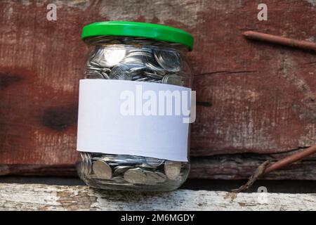 Barattolo con monete ucraine e un'etichetta bianca con posto per i supporti di testo Foto Stock