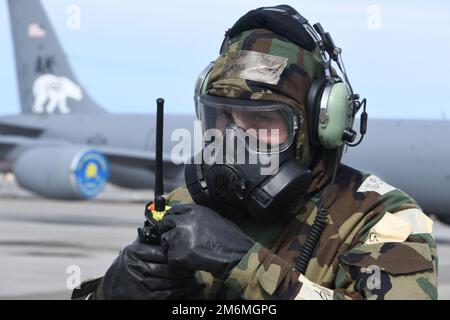 Tecnico. Blayne Kiser del 168th Maintenance Group trasmette informazioni operative tramite la radio garantendo la disponibilità del rifornimento durante l'addestramento in un ambiente simulato e contestato. Gli airmen del 168th Wing Maintenance Group eseguono le operazioni di manutenzione in un ambiente degradato simulato indossando l'attrezzatura di postura protettiva Mission Oriented durante un esercizio di preparazione presso la base dell'aeronautica militare Eielson. Alaska Air National Guard Airmen si preparano regolarmente per le contingenze, stando pronti a rispondere alle esigenze dello stato e della nazione. La 168th Wing garantisce una consegna rapida in volo Foto Stock