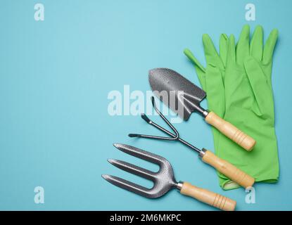 Utensili da giardino per la lavorazione di letti in giardino e guanti verdi in gomma Foto Stock