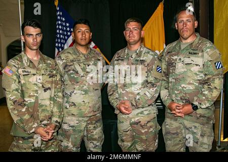 Grant Arnall, SPC. Alejandro Anguiano, staff Sgt. Colby Kuberski e staff Sgt. Steven Shives, un M1A2 Abrams SET V2 squadra di battaglia principale serbatoio assegnato a 2nd battaglione, 69th reggimento armatura, 2nd squadra di combattimento di Brigata Armorata, 3rd Divisione di fanteria, Posa per una foto dopo la cerimonia di apertura della Sullivan Cup a Fort Benning, Georgia, 2 maggio 2022. La competizione si concentra principalmente sulle prestazioni dei soldati che fungono da equipaggio. Foto Stock