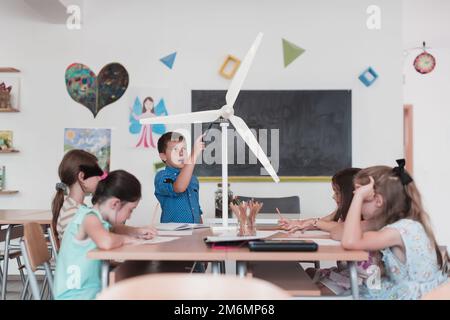 Scuola elementare Robotica STEM Classe diversi Gruppo di Bambini costruzione e programmazione di robot ecologia mulino a vento concetto. Tog Foto Stock
