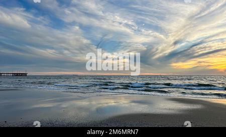 Nuvole spionate riempiono il tramonto sulla spiaggia di Venezia a Los Angeles, California Foto Stock