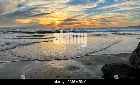 Nuvole spionate riempiono il tramonto sulla spiaggia di Venezia a Los Angeles, California Foto Stock