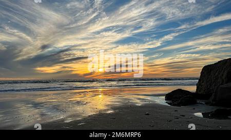 Nuvole spionate riempiono il tramonto sulla spiaggia di Venezia a Los Angeles, California Foto Stock