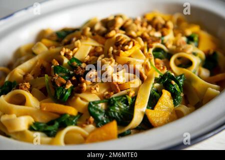 Tagliatelle con spinaci e zucca. Pasta italiana fresca con verdure. Foto Stock