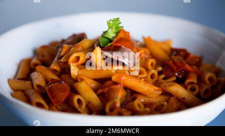 Pasta alla siciliana con acciughe. Pasta con salsa di pomodoro, basilico e olive nere. Foto Stock
