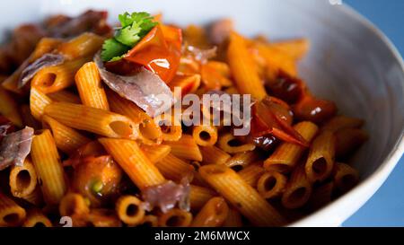 Pasta alla siciliana con acciughe. Pasta con salsa di pomodoro, basilico e olive nere. Foto Stock