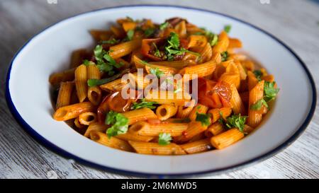 Pasta alla siciliana con acciughe. Pasta con salsa di pomodoro, basilico e olive nere. Foto Stock