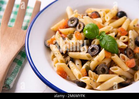 Pasta alla siciliana con acciughe. Pasta con salsa di pomodoro, basilico e olive nere. Foto Stock