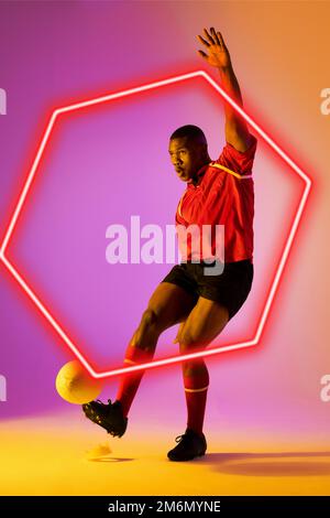 Giocatore di rugby maschile afro-americano calcio palla da esagono illuminato su sfondo gradiente Foto Stock