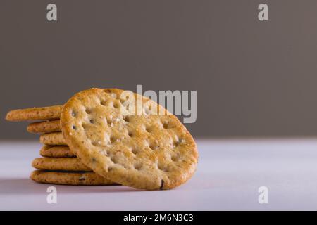 Primo piano dei cracker impilati su sfondo grigio con spazio per le copie Foto Stock