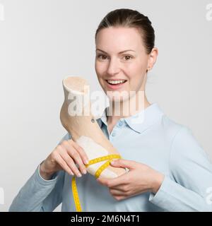 una giovane calzolatrice che presenta un'ultima lavorazione individuale Foto Stock