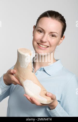 una giovane calzolatrice che presenta un'ultima lavorazione individuale Foto Stock