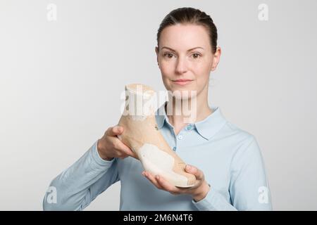 una giovane calzolatrice che presenta un'ultima lavorazione individuale Foto Stock