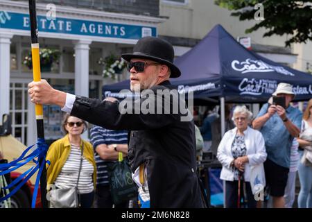 Tom White, che guida la Golowan Band, esibendosi e sfilando nel centro di Penzance, durante la colorata processione del Mazey Day in Cornovaglia in Inghilterra i Foto Stock