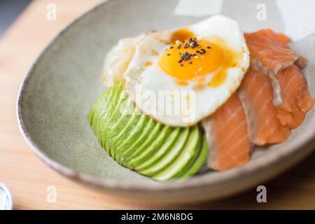 Il salmone donburi è servito in un ristorante giapponese a Tokyo. Piatto combinato giapponese con pollo, riso, uova e verdure. Foto Stock