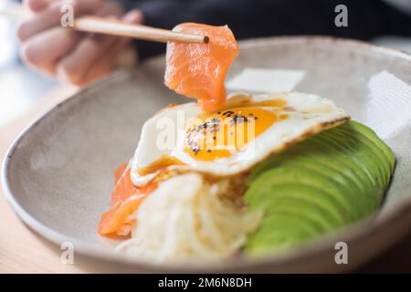 Il salmone donburi è servito in un ristorante giapponese a Tokyo. Piatto combinato giapponese con pollo, riso, uova e verdure. Foto Stock