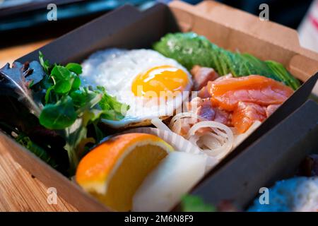 Il salmone donburi è servito in un ristorante giapponese a Tokyo. Piatto combinato giapponese con pollo, riso, uova e verdure. Foto Stock