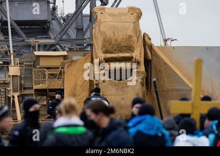 Lützerath, Germania. 05 gennaio 2023, Renania settentrionale-Vestfalia, Lützerath: Attivisti ambientali e poliziotti si trovano di fronte a un escavatore della lignite direttamente sul bordo di demolizione della miniera di lignite Garzweiler II opencast. Secondo le loro stesse dichiarazioni, la polizia ha nuovamente eliminato una barricata nel villaggio lignite occupato di Lützerath. Ciò è stato fatto per motivi di sicurezza. Foto: Rolf Vennenbernd/dpa Credit: dpa picture Alliance/Alamy Live News Foto Stock