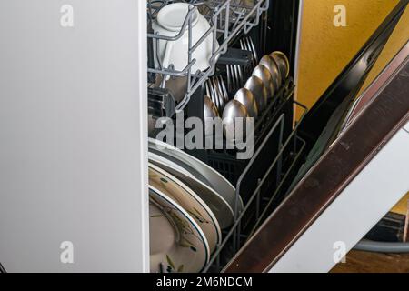 Primo piano di piatti sporchi e altri utensili da cucina in lavastoviglie. Foto Stock