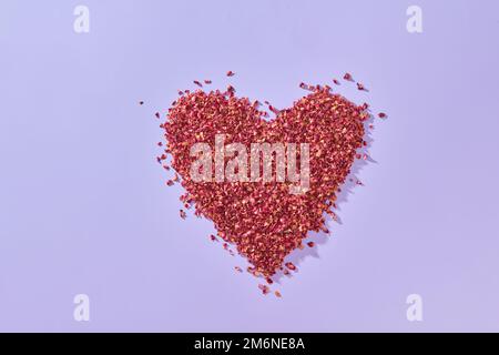 Petali di rosa rossa a forma di cuore. Foto Stock