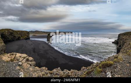 Pittoresca vista autunnale serale della spiaggia di sabbia vulcanica nera dell'oceano di Reynisfjara e delle formazioni rocciose da Capo di Dyrholaey, Vik, SO Foto Stock
