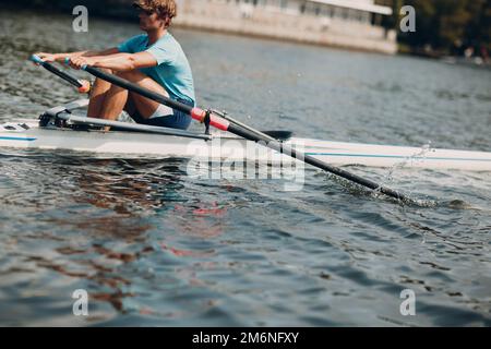 Canottiere sportivo singolo scull man vogatore in barca Foto Stock