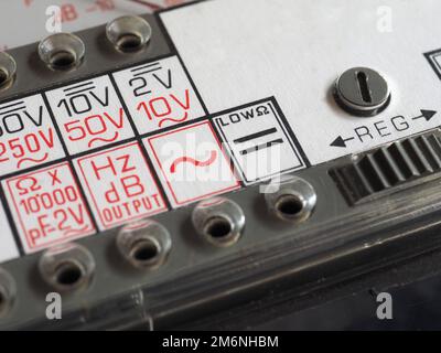 simboli elettrici su uno strumento di misurazione analogico con multimetro d'epoca Foto Stock