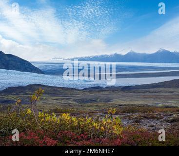 Splendida vista autunnale dal canyon di Mulagljufur al ghiacciaio di Fjallsarlon con la laguna ghiacciata di Breidarlon, Islanda. Non lontano dalla circonvallazione Foto Stock