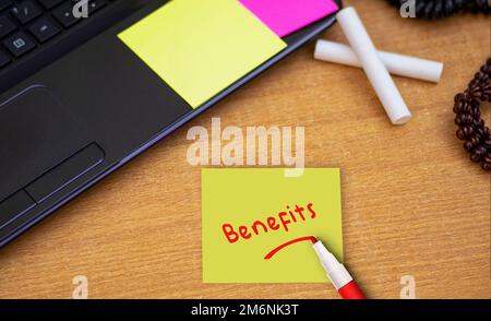 Benefici Sticky note incollate sul tavolo dell'ufficio in ufficio Foto Stock