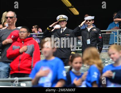 BRIDGEWATER, N.J. -- (3 MAGGIO 2022) STATI UNITI Navy Lt (Chaplain) Stephen Huebscher, a sinistra, da Stillwater, Minn, attaccato alla USS Princeton (CG-59), E Fire Controlman (Aegis) 2nd Classe Jacob Gagliardi da Trenton, NJ che è stazionato a bordo di USS Gettysburg (CG-64) salutano l'inno nazionale a TD Bank Ballpark, campo di casa dei Patrioti Somerset, come parte della settimana della Marina Trenton. STATI UNITI Foto della Marina di Roger S. Duncan, specialista della comunicazione di massa Foto Stock