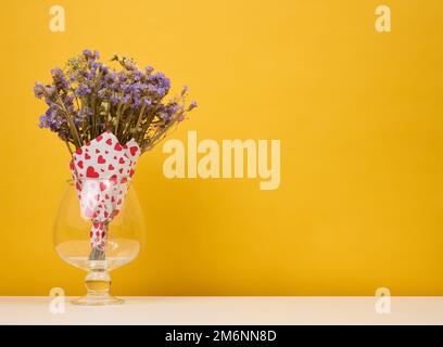 Bouquet secco di fiori selvatici in vaso su fondo giallo Foto Stock